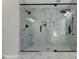 Modern shower featuring marble tiling, a glass enclosure, and dual shower heads at 216 Tennis Court Nw Ln, Kennesaw, GA 30144