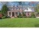 Charming two-story brick home with manicured lawn and inviting front porch, perfect for a Gathering at 4675 Allistair Dr, Cumming, GA 30040