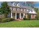 Attractive two-story brick home with a well-manicured lawn, columned porch, and tasteful landscaping at 4675 Allistair Dr, Cumming, GA 30040