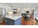 Open kitchen with white cabinetry, a gray kitchen island, stainless steel appliances and hardwood floors at 4675 Allistair Dr, Cumming, GA 30040