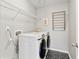 Modern laundry room featuring a washer and dryer set, black tile floors, and wire shelving at 4675 Allistair Dr, Cumming, GA 30040