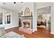 Comfortable living room showcasing a brick fireplace and hardwood floors, with a peek into the adjacent living room at 4675 Allistair Dr, Cumming, GA 30040