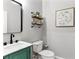 Elegant powder room featuring a green vanity, marble countertop, and stylish mirror at 4675 Allistair Dr, Cumming, GA 30040