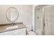 Well-lit bathroom with gray countertop, sink, toilet, and glass shower enclosure at 5120 Post Oak Tritt Ne Rd, Roswell, GA 30075