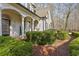 Elegant white brick home exterior featuring a brick walkway and manicured shrubbery at 5120 Post Oak Tritt Ne Rd, Roswell, GA 30075