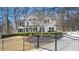 Stately white brick home with black shutters and a manicured front lawn, framed by an elegant gated entrance at 5120 Post Oak Tritt Ne Rd, Roswell, GA 30075