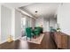 Modern dining area with hardwood floors, a glass table with green chairs, and modern light fixture at 285 Centennial Olympic Park Nw Dr # 904, Atlanta, GA 30313