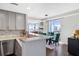 Kitchen featuring stainless steel appliances, gray cabinets, stone backsplash, and an island counter overlooking dining area at 285 Centennial Olympic Park Nw Dr # 904, Atlanta, GA 30313