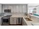 Well-equipped kitchen featuring stainless steel appliances, stone countertops, and stylish gray cabinetry and backsplash at 285 Centennial Olympic Park Nw Dr # 904, Atlanta, GA 30313