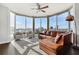 Bright living room with large windows, hardwood floors, and modern furniture and a brown leather sectional sofa at 285 Centennial Olympic Park Nw Dr # 904, Atlanta, GA 30313