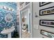 Powder room with blue wallpaper, unique mirror and artwork along the hallway at 560 Dutch Valley Ne Rd # 2207, Atlanta, GA 30324