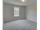 This bedroom features neutral paint, plush carpeting, and a window offering plenty of natural light at 179 Bluffington Way, Marietta, GA 30066