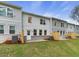 Back exterior view of townhomes featuring gray brick patios and lush green lawns at 179 Bluffington Way, Marietta, GA 30066