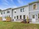 Back exterior view of townhome featuring a door to the patio with gray brick and lush green lawn at 179 Bluffington Way, Marietta, GA 30066