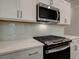 Close up of a modern kitchen with gas cooktop, stainless steel appliances, and white backsplash at 179 Bluffington Way, Marietta, GA 30066