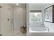 Bathroom featuring a glass shower and separate soaking tub by a window at 674 Allier Ter, Cumming, GA 30041