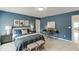 Stylish bedroom featuring blue walls, patterned bedding, and a functional desk area at 674 Allier Ter, Cumming, GA 30041