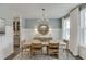 Bright dining room features a modern chandelier, wainscoting, and natural light from the large windows at 674 Allier Ter, Cumming, GA 30041