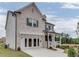 Side view of a brick two-story home with an attached two car garage and covered front porch at 674 Allier Ter, Cumming, GA 30041