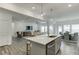 Modern open concept kitchen with island, sink, and adjacent living and dining areas at 674 Allier Ter, Cumming, GA 30041