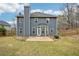 Backyard view with a concrete patio, blue siding, tall chimney, and a well-maintained lawn at 1699 Boulder Walk Se Dr, Atlanta, GA 30316