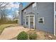 Exterior view of a home with a concrete patio, gray siding, and a chimney under a cloudy blue sky at 1699 Boulder Walk Se Dr, Atlanta, GA 30316