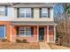 Charming two-story townhome featuring a brick facade, covered front porch and a well-manicured lawn at 2025 Shawn Wayne Se Cir, Atlanta, GA 30316