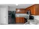 Functional kitchen features wooden cabinetry, black appliances, and a sink with faucet at 2025 Shawn Wayne Se Cir, Atlanta, GA 30316