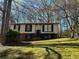 Split-level home with a brick foundation, lawn and mature trees at 6625 Paula Ct, Lithonia, GA 30038