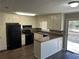 Bright kitchen boasts white cabinets, black appliances, and a sliding door to the backyard deck at 6625 Paula Ct, Lithonia, GA 30038