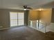 Cozy living room featuring neutral paint, carpet, a ceiling fan, and a view of the stairway at 6625 Paula Ct, Lithonia, GA 30038