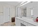 Bright bathroom featuring a white vanity and large mirror reflecting the shower and soaking tub at 1325 Richland Creek Ct, Buford, GA 30518