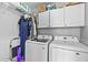 Bright laundry room with white cabinets, washer, and dryer at 1325 Richland Creek Ct, Buford, GA 30518