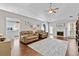 Open-concept living room featuring a fireplace, ceiling fan, and hardwood floors at 1325 Richland Creek Ct, Buford, GA 30518