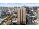 Aerial view of a high-rise building, pool, and tennis court in a bustling city setting with green spaces at 325 E Paces Ferry Ne Rd # 504, Atlanta, GA 30305