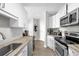 Galley kitchen design featuring white cabinetry, a tile backsplash, and stainless steel appliances at 325 E Paces Ferry Ne Rd # 504, Atlanta, GA 30305