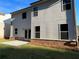 Backyard view of the home with a gray exterior, dark-framed windows, and small concrete patio at 4375 Easter Lily Ave Lot 81, Buford, GA 30519