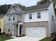 Charming two-story home featuring a brick and siding exterior, a two-car garage, and a well-manicured lawn at 4375 Easter Lily Ave Lot 81, Buford, GA 30519