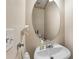 This powder room features a pedestal sink and oval mirror at 8819 Lakecrest Way, Union City, GA 30291