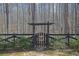 A charming wooden gate features a unique butterfly design and provides access through a dark wooden fence into a wooded area at 1420 Orange Shoals Dr, Canton, GA 30115