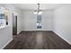 Cozy dining room with wood floors, a modern chandelier, and a glass door leading to the backyard at 230 Nina Cir, Locust Grove, GA 30248