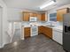 Well-lit kitchen features wooden cabinets, white appliances, and new vinyl floors at 230 Nina Cir, Locust Grove, GA 30248