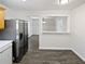 Modern kitchen with stainless steel refrigerator and view into adjacent living area at 230 Nina Cir, Locust Grove, GA 30248