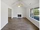 Bright living room featuring a fireplace, modern ceiling fan, and dark wood-look floors at 230 Nina Cir, Locust Grove, GA 30248