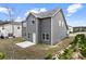 Angled view of the back of a gray home featuring a small patio and grassy yard at 2466 Bear Mountain St, Lithonia, GA 30058