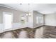 Well-lit dining room with hardwood floors, wainscoting, stylish chandelier, and convenient access to the outdoor patio at 2466 Bear Mountain St, Lithonia, GA 30058