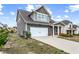 View of a two-story home with a two-car garage, concrete driveway and landscaping at 2466 Bear Mountain St, Lithonia, GA 30058