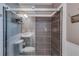 Modern bathroom featuring gray tiled walls, glass shower doors, and contemporary fixtures at 3570 Mill Creek Drive Sw Dr, Smyrna, GA 30082