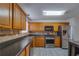 Well-lit kitchen with stainless steel appliances, wooden cabinets, and stylish stone tile backsplash at 3570 Mill Creek Drive Sw Dr, Smyrna, GA 30082