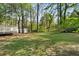 A lush green lawn is surrounded by tall shade trees in this spacious backyard at 7323 Howard Pl, Jonesboro, GA 30236